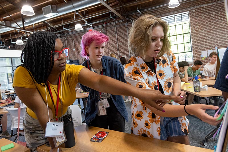 Students looking at a noteboard.