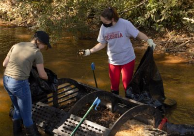V - Students help install trap to clean creek